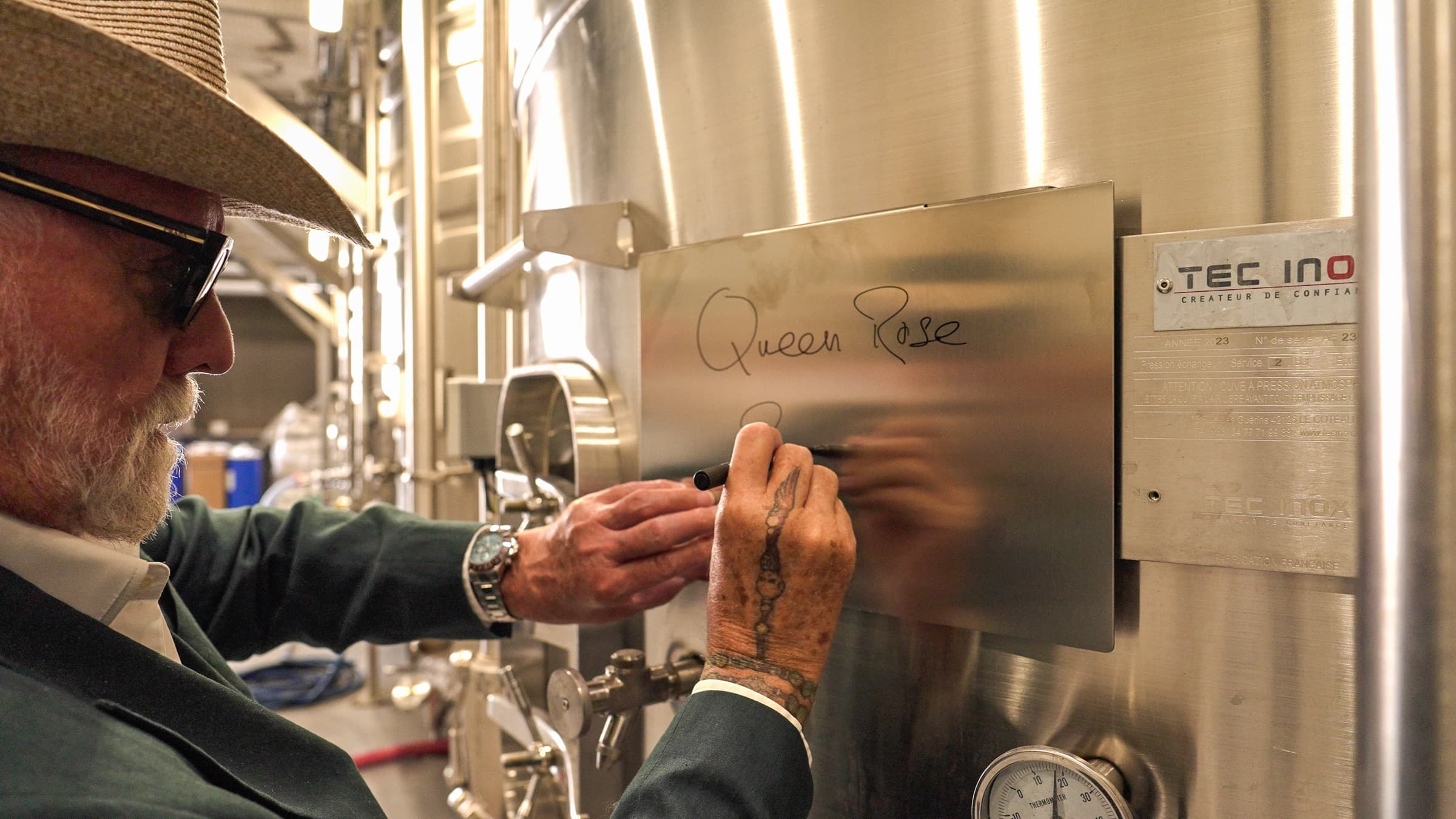 Roger Taylor signing the wine tank at Les Caves du Commandeur